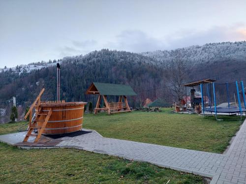 a park with a playground and a gazebo at APUSENI HOLIDAYS in Răchiţele