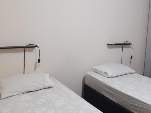 two beds sitting next to each other in a room at Casa Livramento Rivera diária in Santana do Livramento