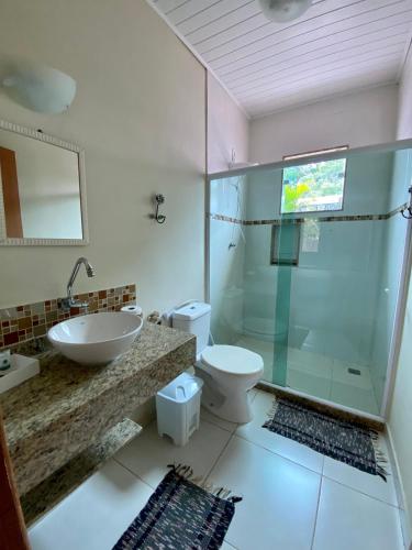 a bathroom with a sink and a toilet and a shower at Pousada OCEAN in Saquarema