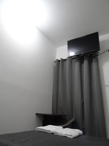 a bedroom with a bed with a television and curtains at Hostel Cuartos de Renta Nuevos Huasteca Potosina WIFI A/C in Ciudad Valles