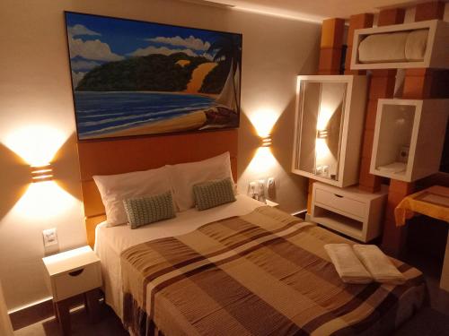 a bedroom with a bed and a painting on the wall at Ilusion Flats Aconchego de Ponta Negra in Natal