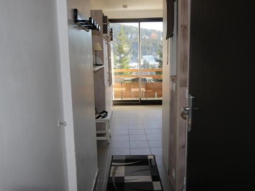 un couloir avec une porte s'ouvrant sur une chambre avec vue dans l'établissement Studio Chamrousse, 1 pièce, 3 personnes - FR-1-340-264, à Chamrousse