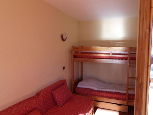 une petite chambre avec deux lits superposés et un canapé dans l'établissement Studio divisible 4 pers, centre station, balcon sud, proche pistes, animaux admis - FR-1-181-2699, à La Plagne Tarentaise