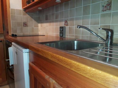 un comptoir de cuisine avec un évier en acier inoxydable dans l'établissement Studio cosy à Plagne Centre avec balcon, proche pistes et centre, skis aux pieds - FR-1-181-2692, à La Plagne Tarentaise