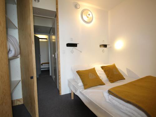 - une petite chambre avec un lit et des oreillers jaunes dans l'établissement Appartement rénové 3 pièces · Balcon · WIFI · Loupe - FR-1-346-538, à Arc 2000