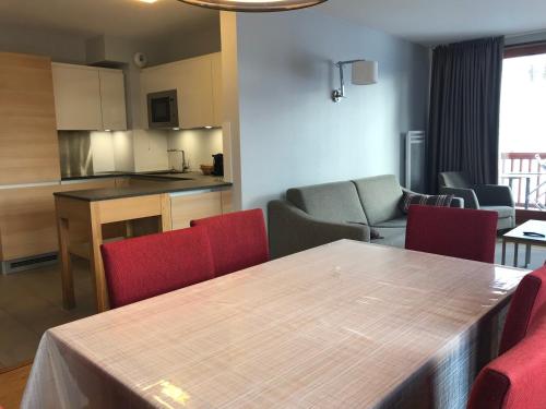 une cuisine et un salon avec une table et des chaises dans l'établissement Appartement spacieux avec parking, balcon et accès piscine - Front de neige - FR-1-346-536, à Arc 1800