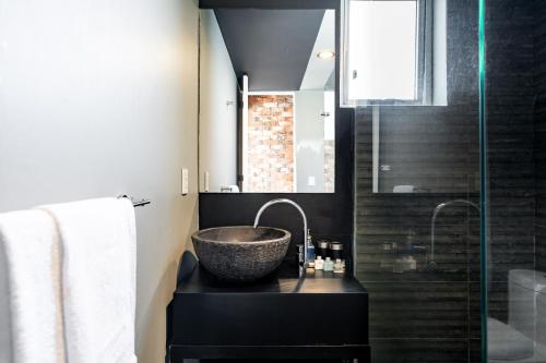 a bathroom with a bowl sink and a shower at Departamento con las mejores vistas de la ciudad en Condesa - pool - gym - parking - AC in Mexico City