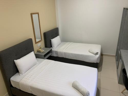 2 bedden in een kleine kamer met een spiegel bij Pusat Belia Antarabangsa in Kuala Lumpur