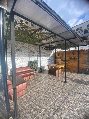 un patio con toldo, mesa y banco en Destino Nómada Calle 11 n 1-38, en Bogotá