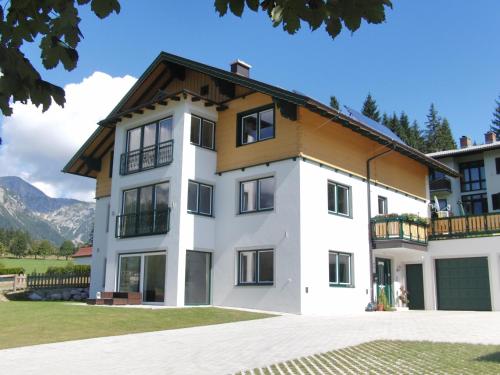 a large white house with a brown roof at Apartment Österreich in Ramsau am Dachstein