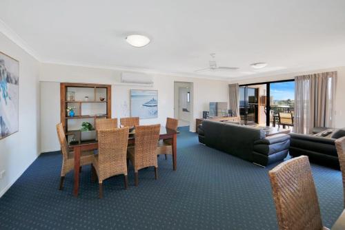 a living room with a table and a couch at 404a Coral Sands in Bargara