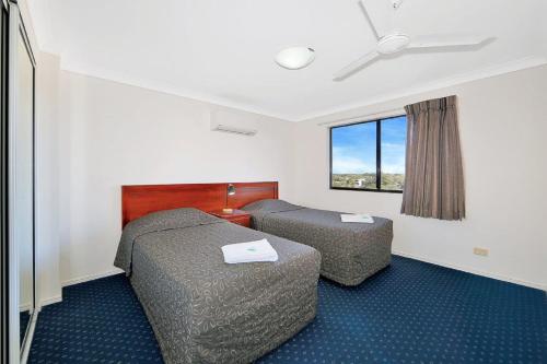 ein Hotelzimmer mit 2 Betten und einem Fenster in der Unterkunft 404a Coral Sands in Bargara