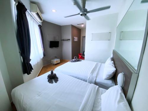 a hotel room with two beds and a ceiling fan at D'concept Hotel Kulim in Kulim