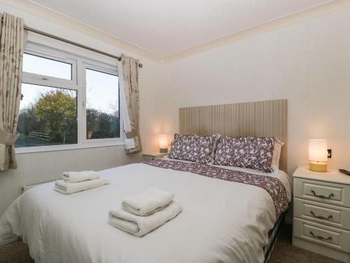 1 dormitorio con 1 cama con toallas en Blenheim Lodge, en Puxton