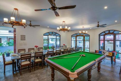 a room with a pool table and tables and chairs at Luxurious Villa with Private Swimming Pool, Kids Pool, Games, Private Parking in Calangute