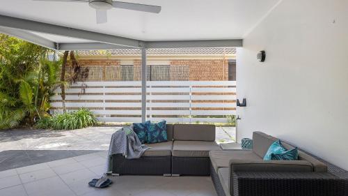 a patio with a couch and a table and chairs at Baie de Salamandre in Salamander Bay