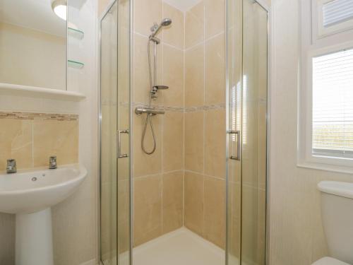 bagno con doccia e lavandino di Harvester Lodge a Puxton