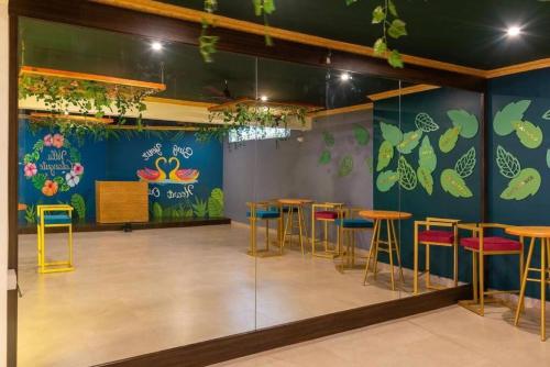 a room with tables and chairs and a wall with plants at Luxurious Villa with Private Swimming Pool, Kids Pool, Games, Private Parking in Calangute