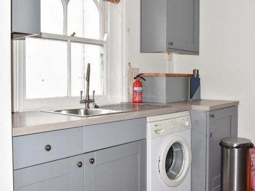 a kitchen with a sink and a washing machine at Petra 1-uk39857 in Marazion
