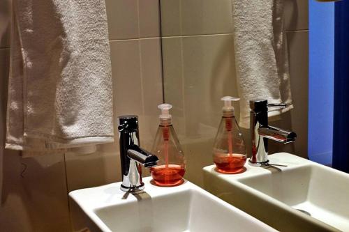 two bottles of alcohol are sitting on a bathroom sink at Coveted Palms Village Pension in Jeju