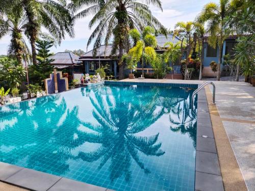 a blue swimming pool with a palm tree on it at Palm Tian Homes A17 in Ban Chong Phli