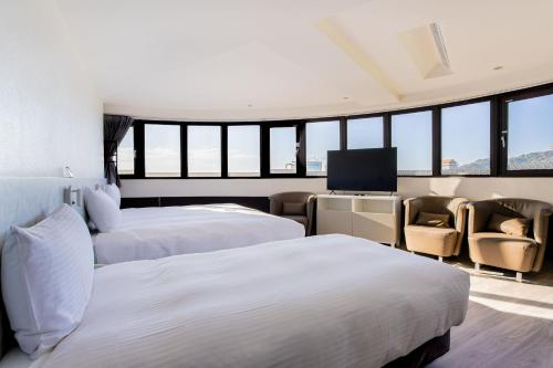 a hotel room with two beds and a flat screen tv at Hub Hotel - Songshan Airport Branch in Taipei