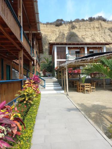 a walkway next to a building with a table and chairs at Canoa South Beach in Canoa