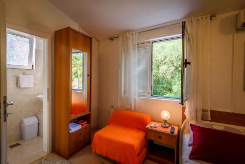 a small bathroom with an orange chair and a toilet at Apartments Goge - 90m from beach in Gradac