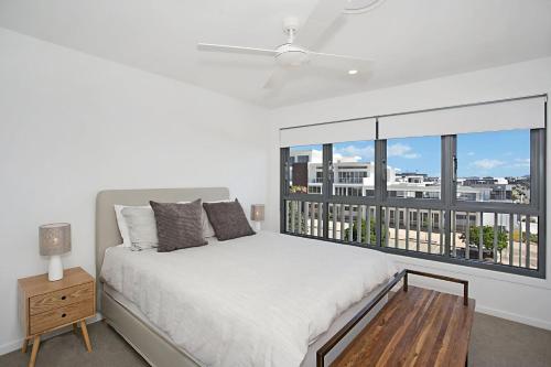 um quarto branco com uma cama e uma janela em Ocean Terrace em Kingscliff