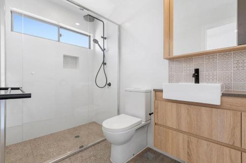 uma casa de banho com um WC, um chuveiro e um lavatório. em Ocean Terrace em Kingscliff
