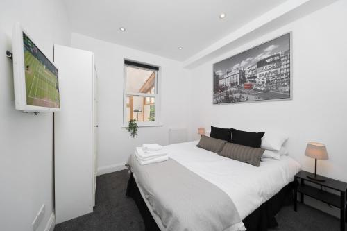 a bedroom with a large bed and a tv at Your Own House, 2 Bedr, 3 Beds, 2,5 Bath, Covent Gdn in London