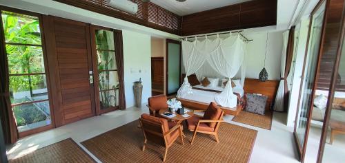 a bedroom with a bed and a table and chairs at Cahaya Indah Villas in Ubud