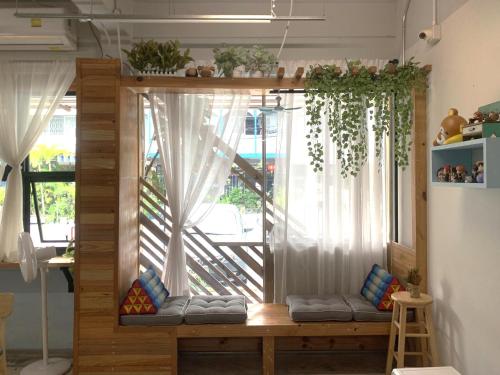 a room with a window with white curtains and a bench at Sleep Sheep Phuket Hostel SHA in Phuket