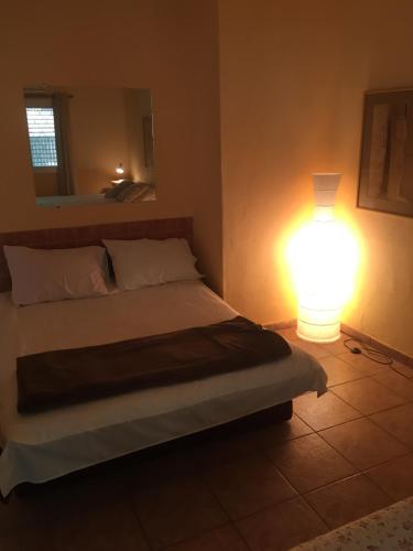 a bedroom with a bed and a light on the wall at Gil's Guest Rooms in Neve Zohar