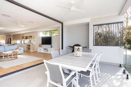 a dining room and living room with a table and chairs at Ohana On Hungerford in Kingscliff