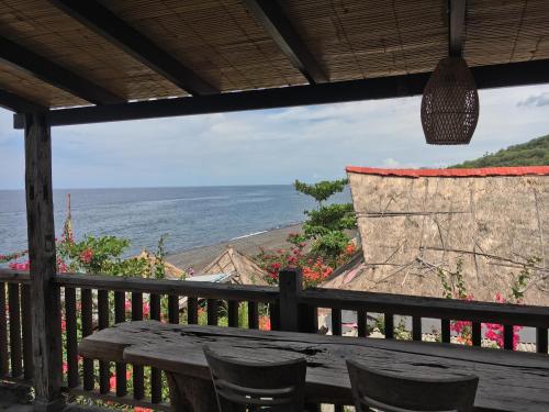 a table and chairs on a balcony with a view of the ocean at Amed Sunset Beach in Amed