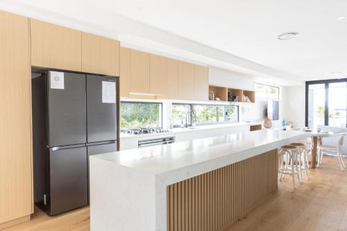 a kitchen with a refrigerator and a counter top at Ohana On Hungerford in Kingscliff