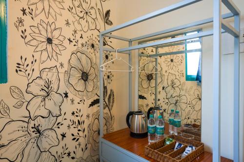a bathroom with a flowery wallpaper on the wall at Shalom Backpackers Anjuna Goa in Anjuna
