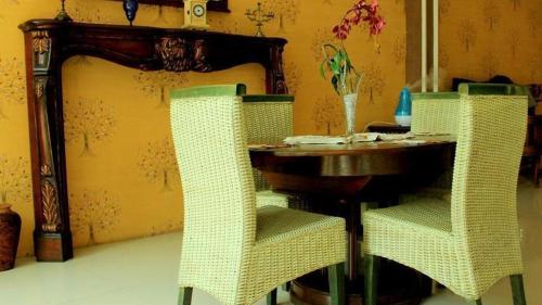 a table and two chairs with a wooden table at Mojokerto Classic Homestay in Mojokerto