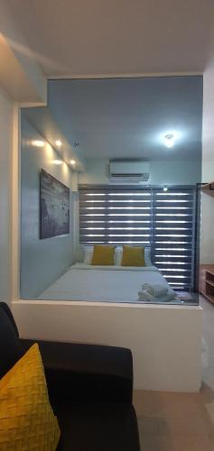 Schlafzimmer mit einem großen weißen Bett und einem Fenster in der Unterkunft Shore 2 residences condominium in Manila