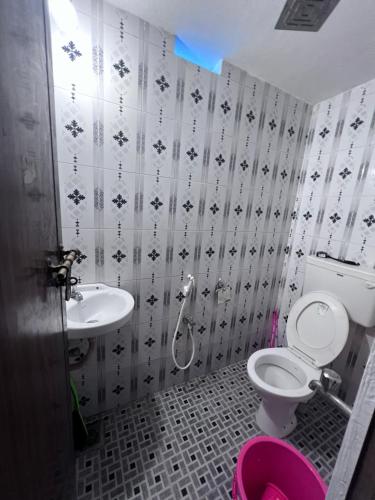 een badkamer met een toilet en een wastafel bij Hammock Beach Home in Alleppey