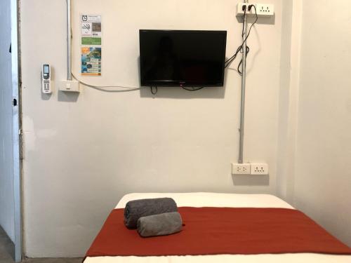 a room with a bed with a tv on the wall at Sleep Sheep Phuket Hostel SHA in Phuket Town