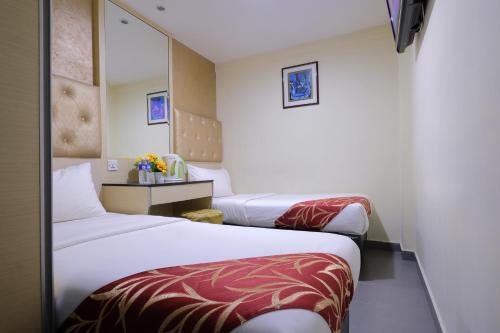 a hotel room with two beds and a television at Sandpiper Hotel Single Room, Long Stay and Short Hours in Singapore