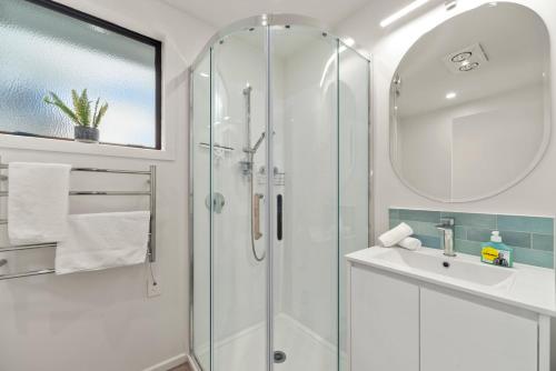 a bathroom with a glass shower and a sink at Garden Grove Gem - Lake Taupō Holiday Home in Taupo