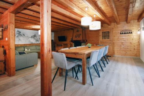 une salle à manger avec une table et des chaises en bois dans l'établissement 2AlpesChalets - Chalet Marie 1 - Standing et Sauna au pieds des pistes, à Les Deux Alpes