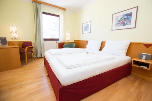 a hotel room with a large bed in a room at Das Reinisch Just Rooms in Schwechat