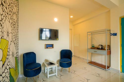 a waiting room with two blue chairs and a desk at Shalom Backpackers Anjuna Goa in Anjuna