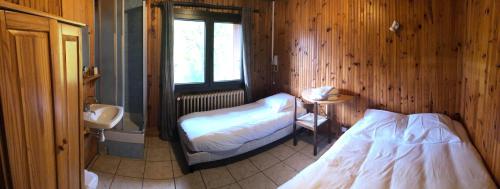 a bedroom with two beds and a sink and a bathroom at Auberge de Pra-Loup in Pra-Loup