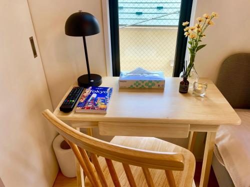 a table with a remote control and books on it at Ken's Place四谷 in Tokyo