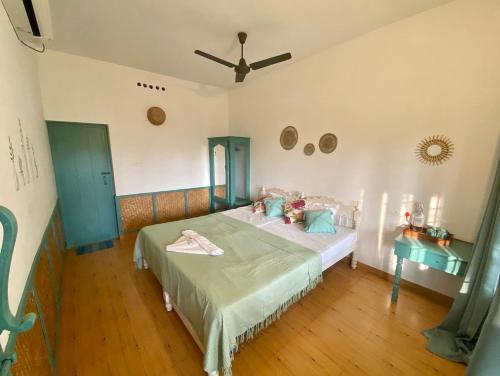 a bedroom with a bed and a ceiling at Petit Ana Beach Retreat in Varkala